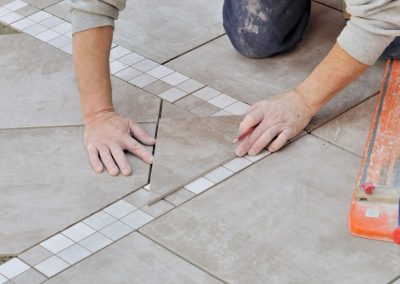 Artisan carreleur qui pose du carrelage
